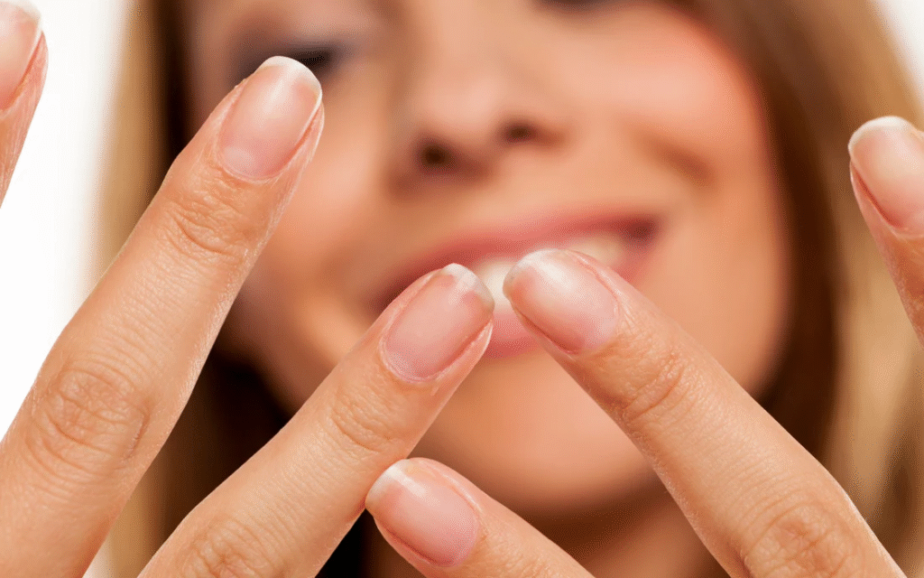 Happy woman showing strong healthy nails after using NanoDefense Pro supplement.